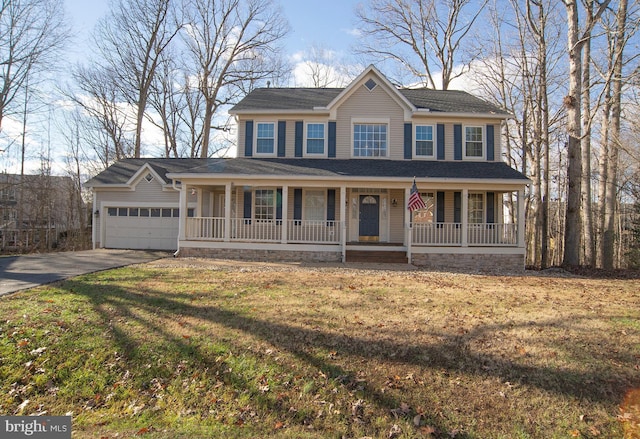 view of front of house with a front yard, a porch, and a garage