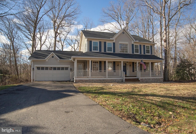 view of front facade featuring a porch, a front yard, and a garage