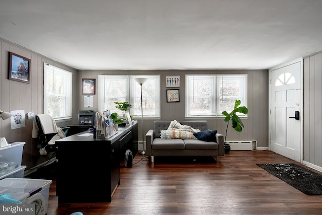 office area with a baseboard radiator, dark hardwood / wood-style floors, and wood walls