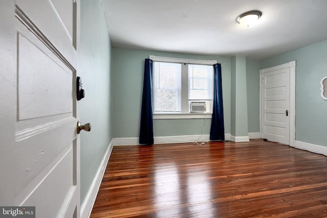 unfurnished bedroom with cooling unit and dark hardwood / wood-style flooring