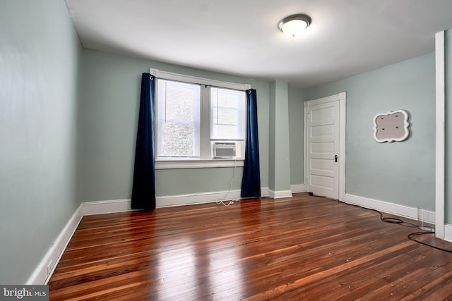 spare room with cooling unit and dark wood-type flooring