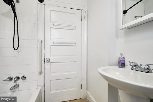 bathroom featuring tiled shower / bath combo and sink