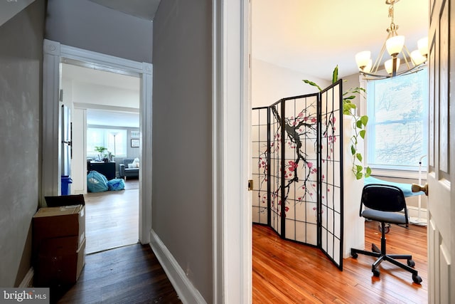 interior space with wood-type flooring, a wealth of natural light, and a chandelier