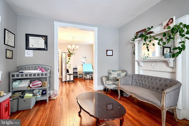 sitting room with hardwood / wood-style flooring and a notable chandelier