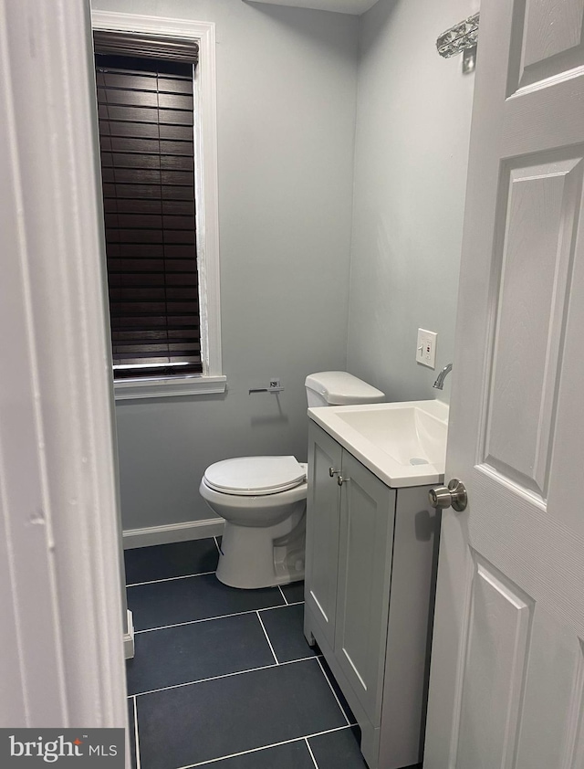 bathroom with tile patterned flooring, vanity, and toilet