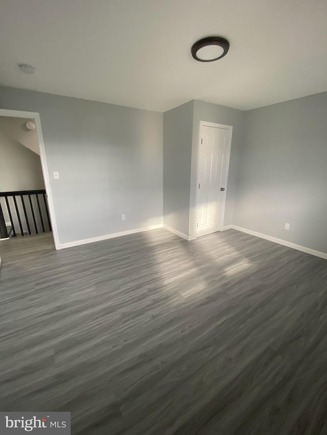 spare room with dark wood-type flooring