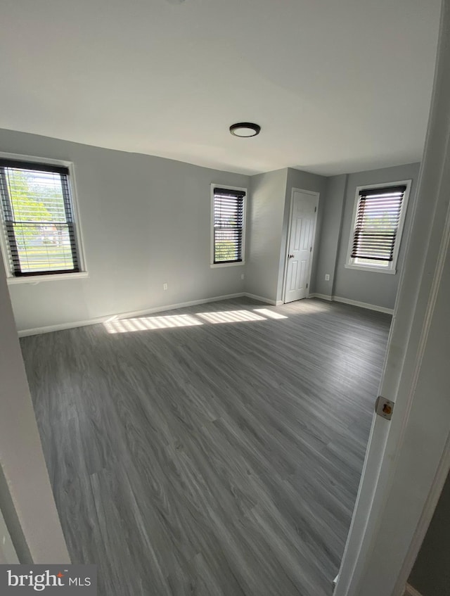 spare room featuring dark hardwood / wood-style floors and plenty of natural light