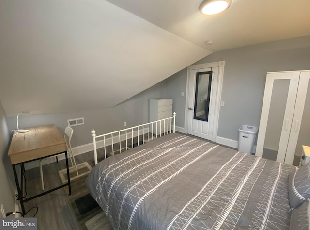 bedroom with hardwood / wood-style flooring and lofted ceiling