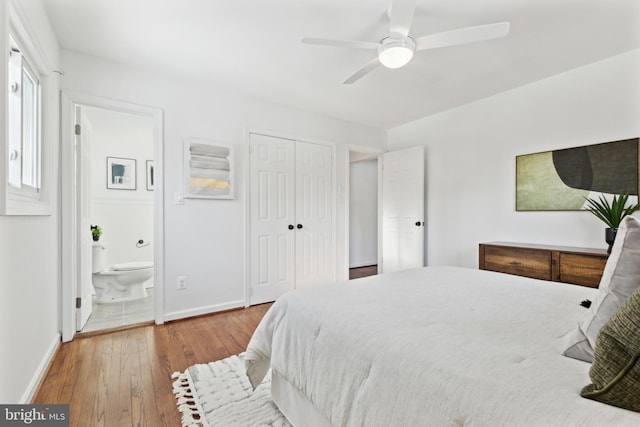 bedroom with hardwood / wood-style flooring, a closet, connected bathroom, and ceiling fan