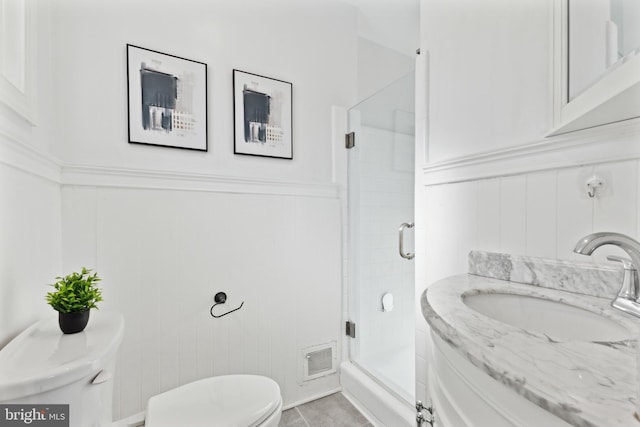 bathroom with toilet, an enclosed shower, tile patterned floors, and vanity