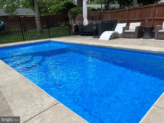 view of pool with a patio area and a hot tub