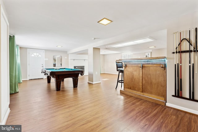 playroom with light wood-type flooring, bar area, billiards, and a fireplace