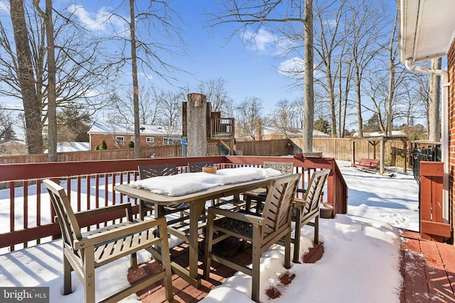 snow covered deck with a playground