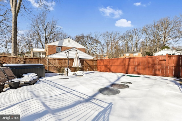 snow covered patio featuring a hot tub