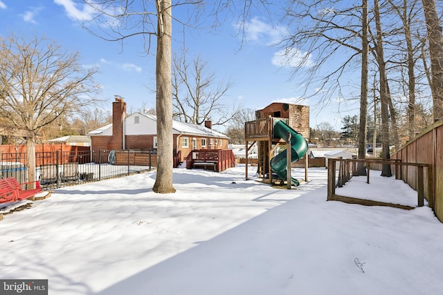 yard layered in snow featuring a playground