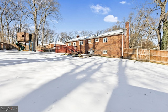 yard layered in snow featuring a playground