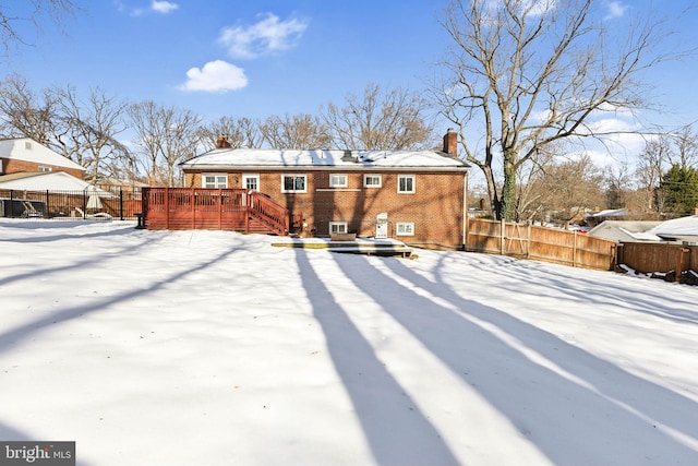 snow covered house featuring a deck