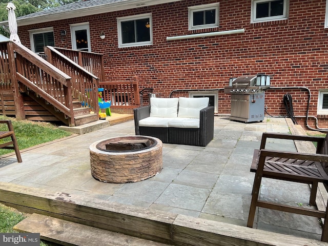 view of patio with a fire pit, area for grilling, and a wooden deck