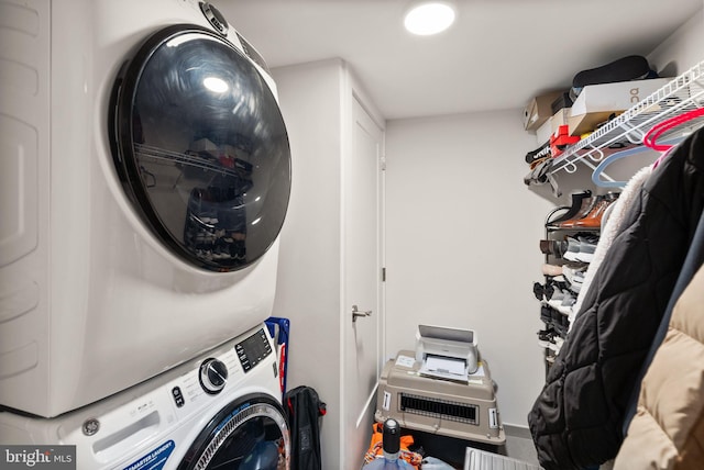 clothes washing area with stacked washing maching and dryer