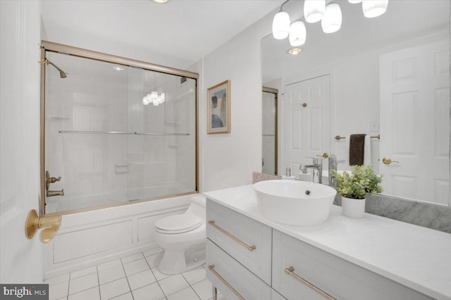 full bathroom featuring toilet, bath / shower combo with glass door, tile patterned floors, and vanity