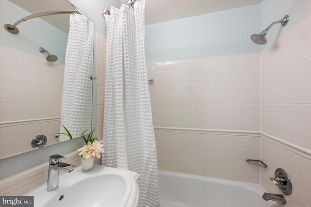 bathroom featuring shower / bathtub combination with curtain and sink