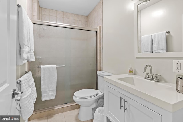 bathroom with tile patterned floors, toilet, a shower with door, and vanity