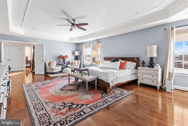 bedroom featuring crown molding, ceiling fan, a raised ceiling, and hardwood / wood-style floors