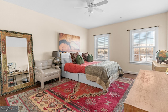 bedroom with dark wood-type flooring, ceiling fan, and multiple windows