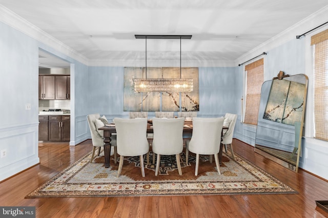 dining area featuring ornamental molding, dark hardwood / wood-style flooring, and a notable chandelier