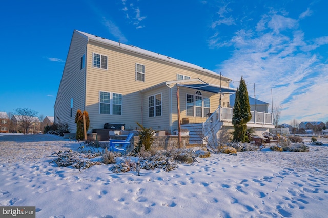 snow covered back of property with covered porch