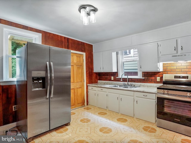 kitchen featuring white cabinets, appliances with stainless steel finishes, backsplash, and sink