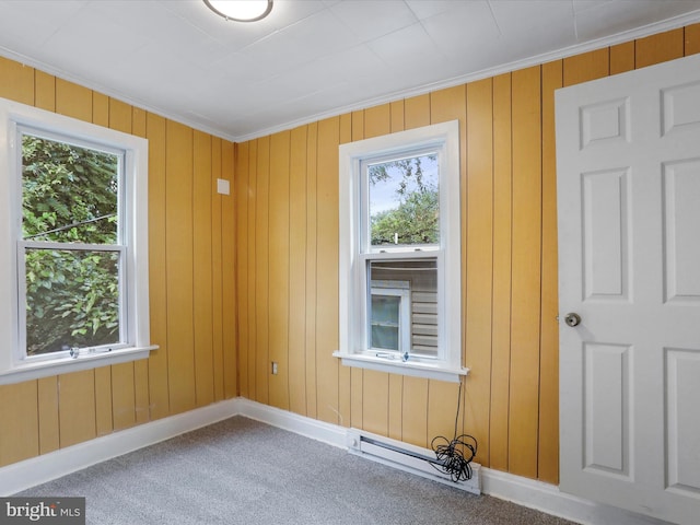 carpeted empty room featuring ornamental molding and a baseboard radiator