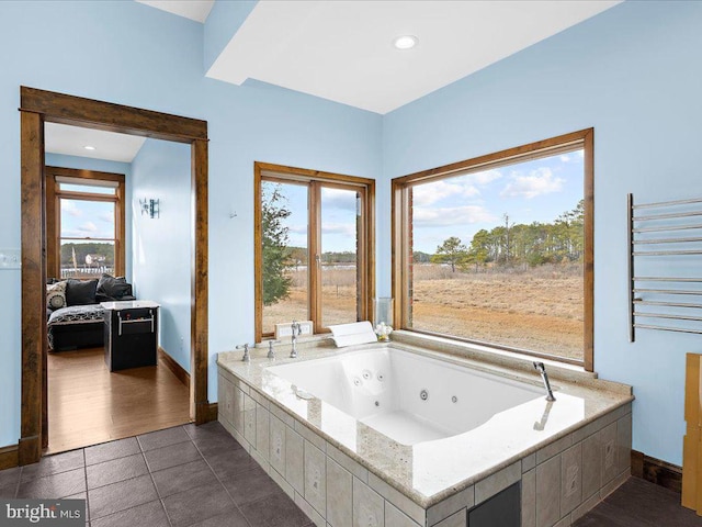 bathroom featuring tile patterned floors, radiator, and a bath