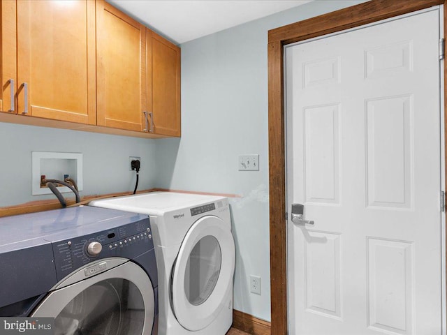 laundry area with washer and dryer and cabinets