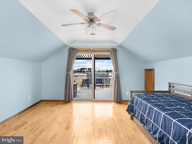 unfurnished bedroom featuring access to exterior, ceiling fan, wood-type flooring, and vaulted ceiling