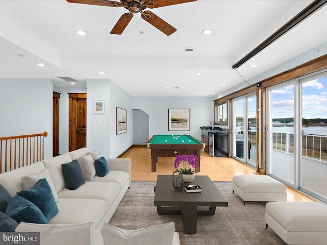 playroom with ceiling fan, a water view, light hardwood / wood-style floors, and pool table