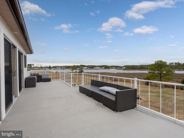 view of patio featuring a water view, an outdoor hangout area, and a balcony