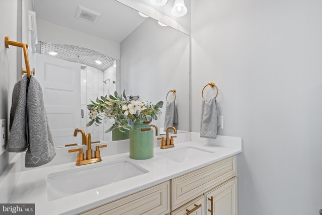 bathroom with a tile shower and vanity