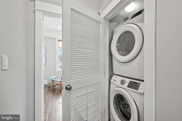 washroom featuring stacked washing maching and dryer and hardwood / wood-style flooring