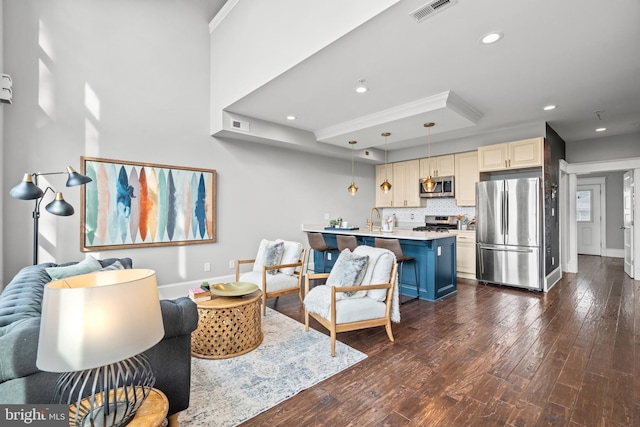 living room with dark hardwood / wood-style flooring, sink, and ornamental molding