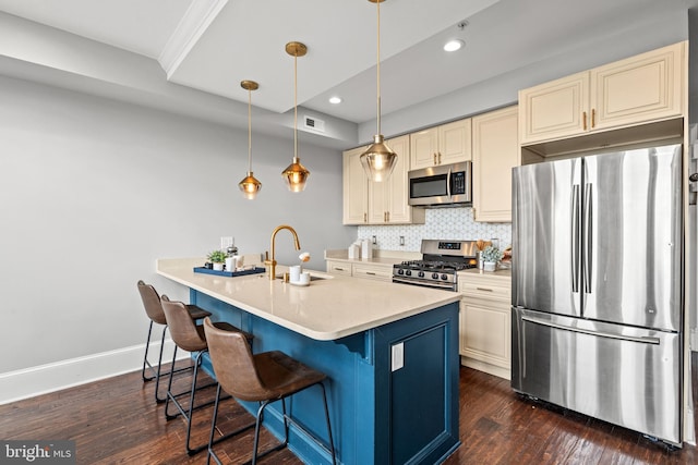 kitchen with a kitchen breakfast bar, sink, tasteful backsplash, decorative light fixtures, and stainless steel appliances