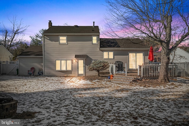 back house at dusk featuring a deck