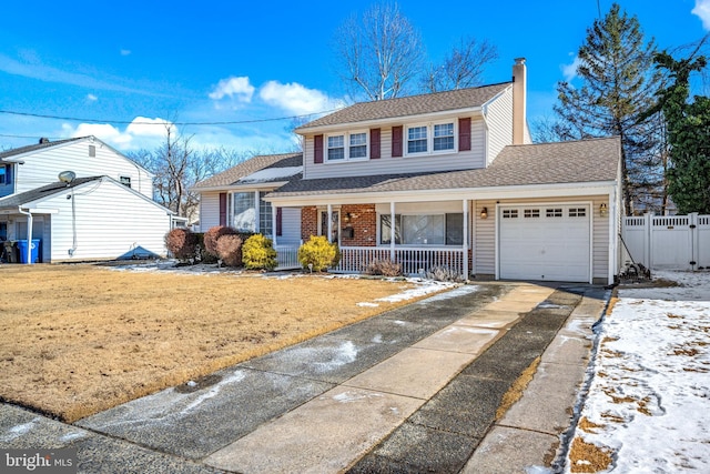 view of front property with a garage, a yard, and covered porch