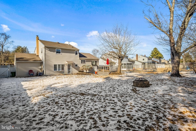 rear view of house featuring a deck and a fire pit