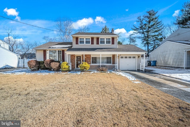 view of property with a porch, a garage, and a front yard