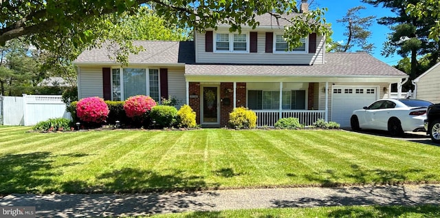 tri-level home with a garage, a front yard, and a porch