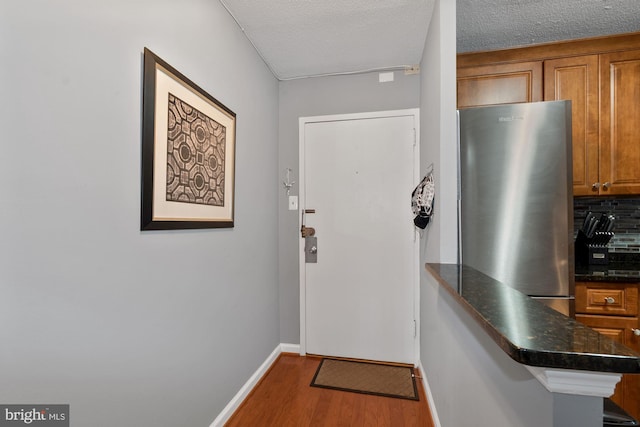 doorway to outside featuring hardwood / wood-style floors and a textured ceiling