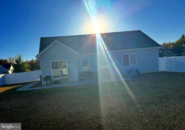 back of property with a patio area and a yard