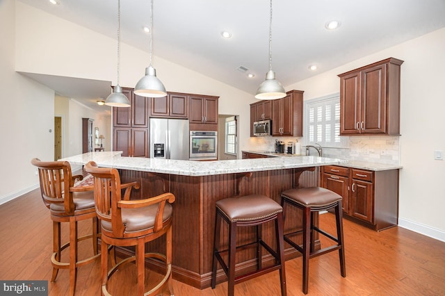 226 Loyal Dr, Mechanicsburg, PA 17050 - kitchen featuring appliances with stainless steel finishes, lofted ceiling, light wood-style flooring, baseboards, and backsplash