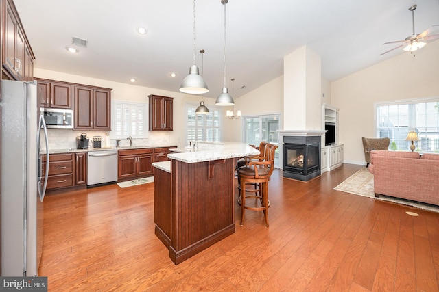 226 Loyal Dr, Mechanicsburg, PA 17050 - kitchen featuring appliances with stainless steel finishes, open floor plan, a sink, light wood-style flooring, and high vaulted ceiling
